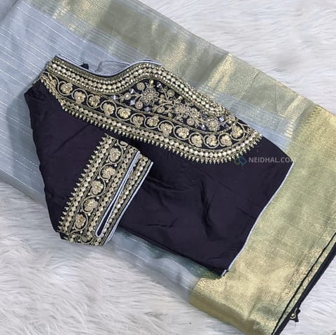 CODE WS1013 : Light grey tissue organza saree(thin and lightweight) with thin gold zari woven pattern all over, tissue gold zari woven borders with tapings, pallu with tapings, contrast plain running blouse with tapings. Heavy deep blue readymade blouse with rich gota patch, thread and stone and real mirror work on front side , sweetheart neckline, elbow length sleeves(length:10 inches), tassels at back side of blouse (height: 15inches, arm hole-to-arm hole:19inches, fits upto size 40,L size, can be altered to smaller sizes).DRY CLEAN RECOMMENDED.